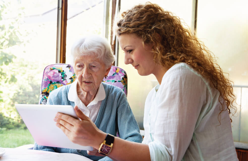 Senior woman reading with a staff member