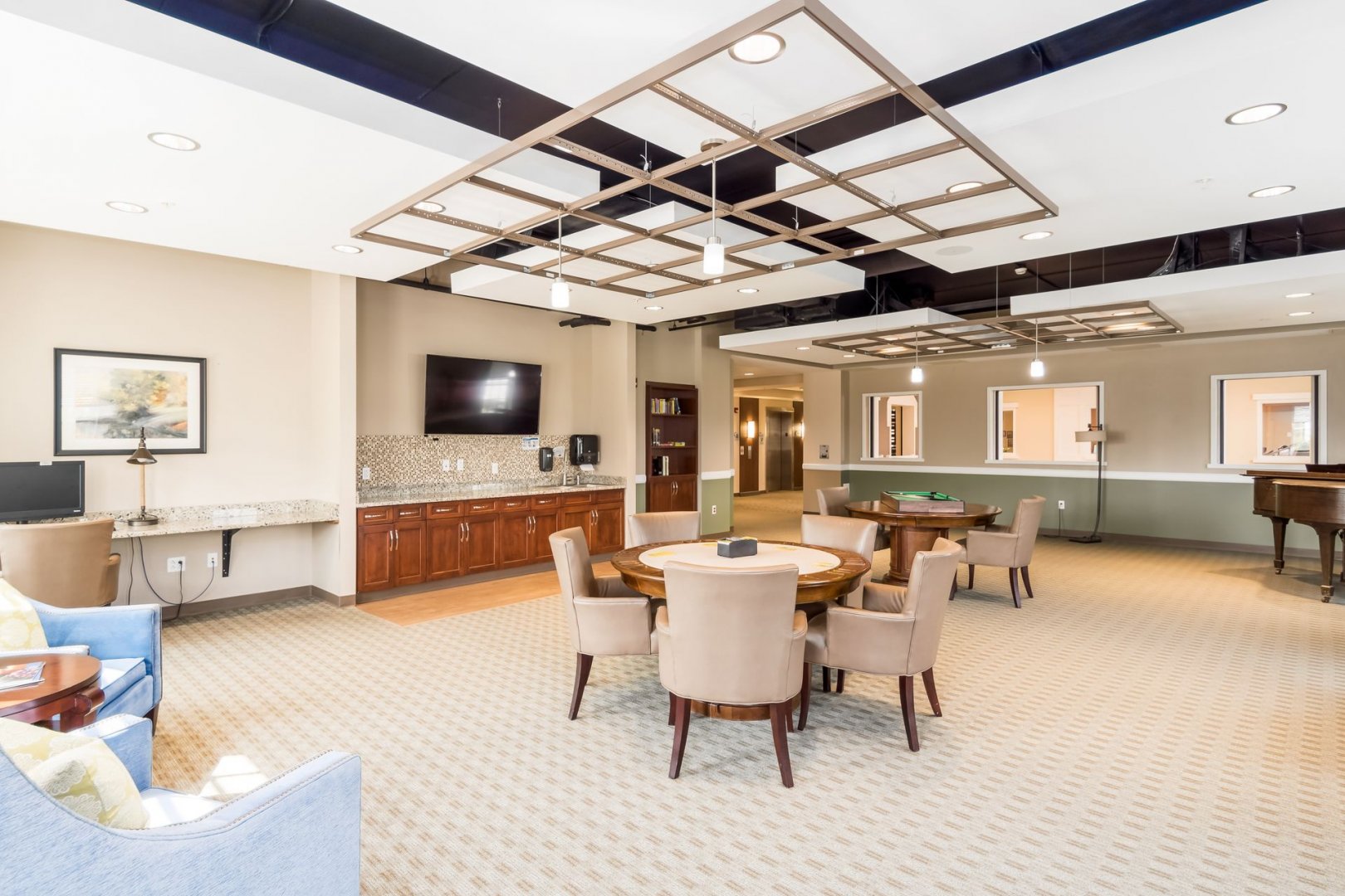 Community Room in Senior Living Facility Comfortable community room with seating, tables, and a kitchenette in a senior living community.