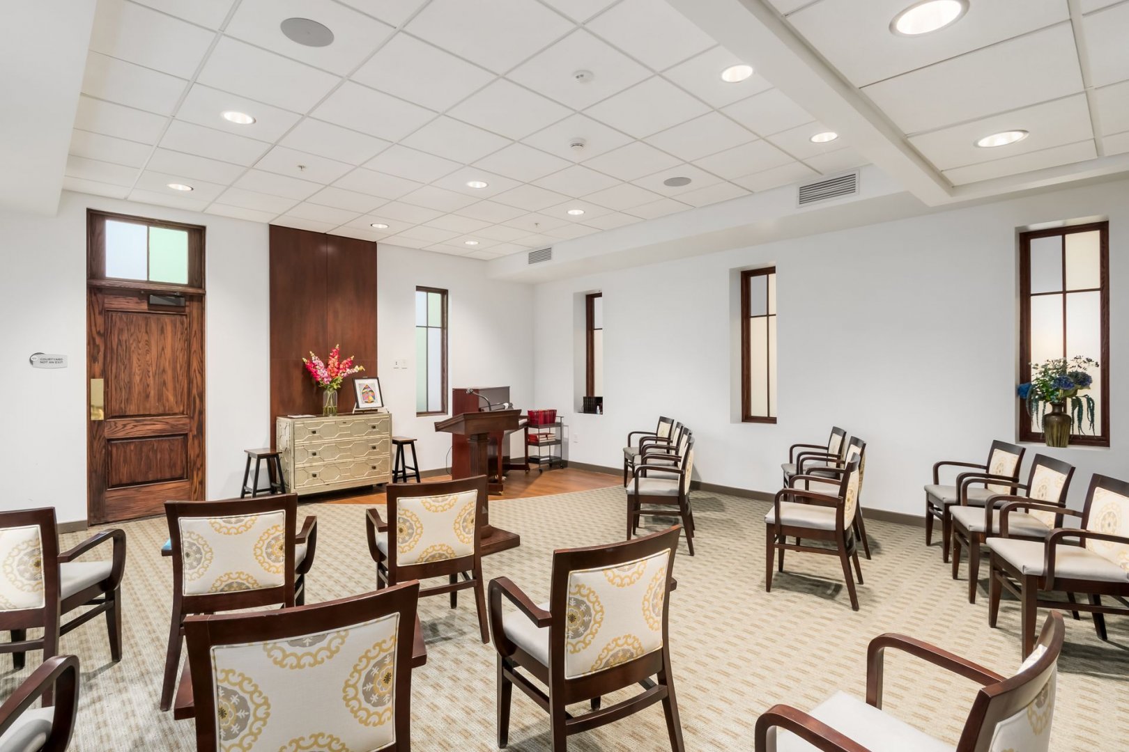 Elegant Meeting Room in Senior Living Community Meeting room with wooden chairs and pastel-patterned cushions in a senior living community.