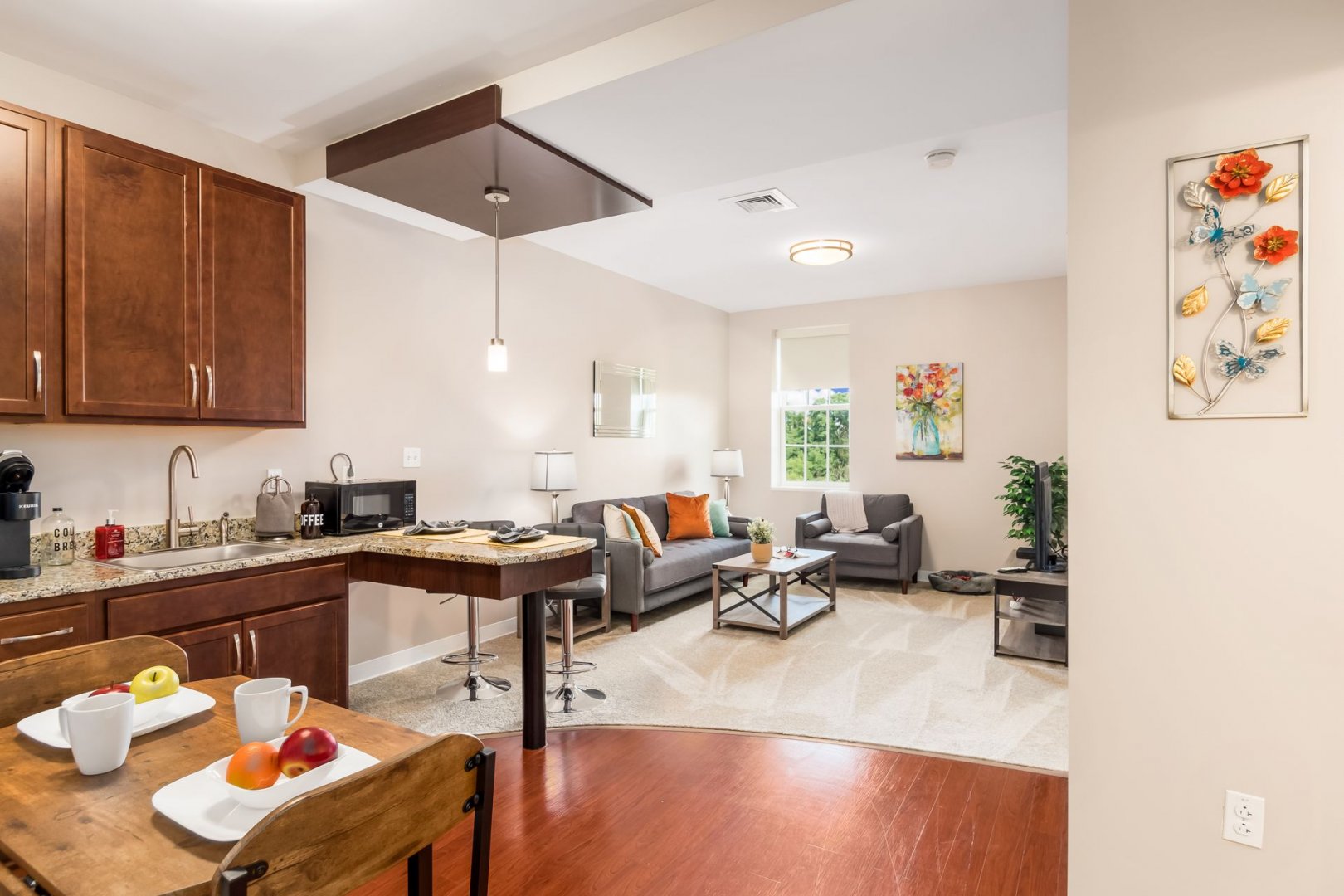 Modern Senior Living Unit Interior Modern senior living unit with cozy sitting area, kitchenette, and decorative wall art.