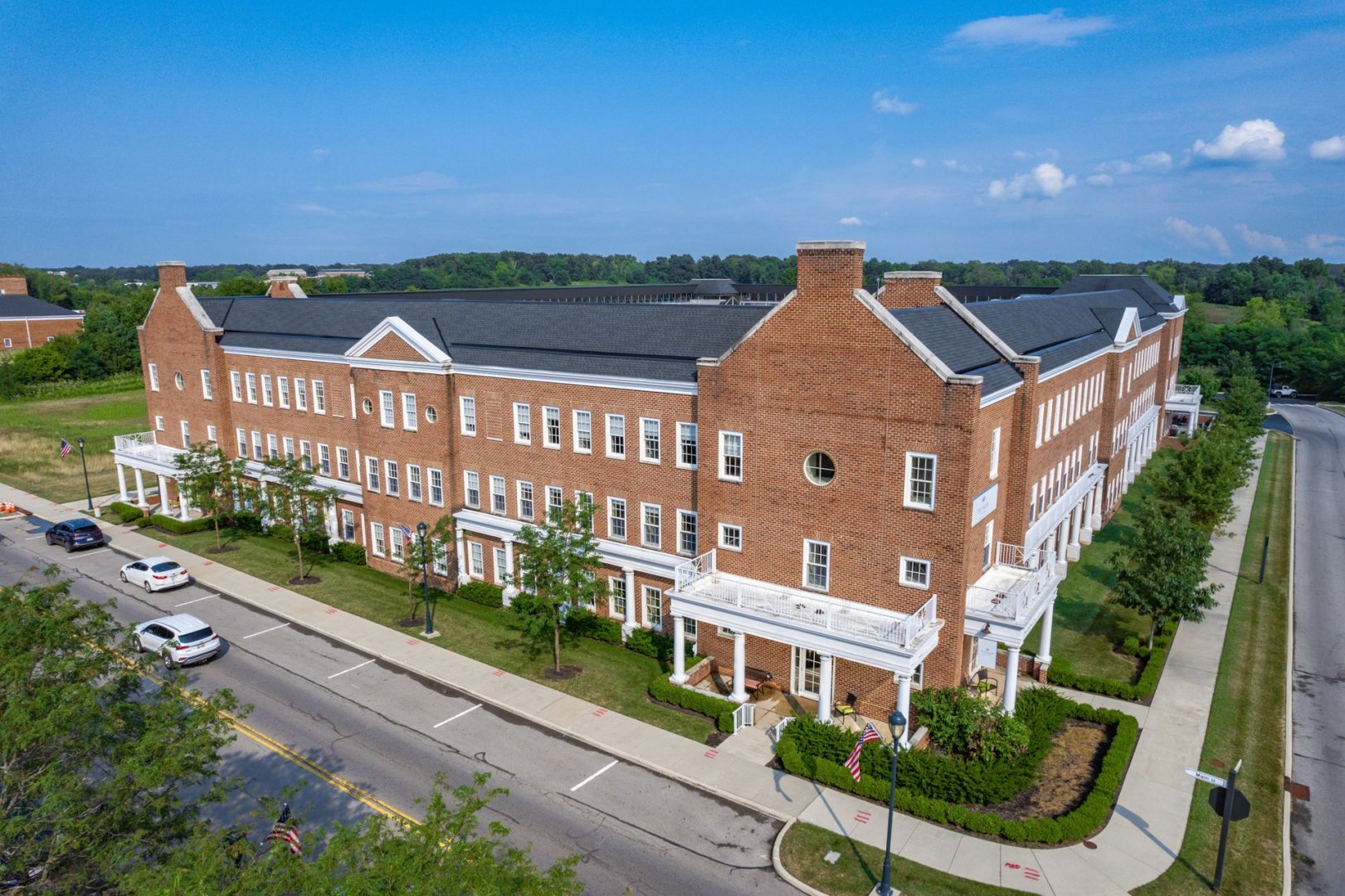 Red Brick Senior Living Community Building in New Albany, OH Red brick building of a senior living community with trees and parked cars along the street.