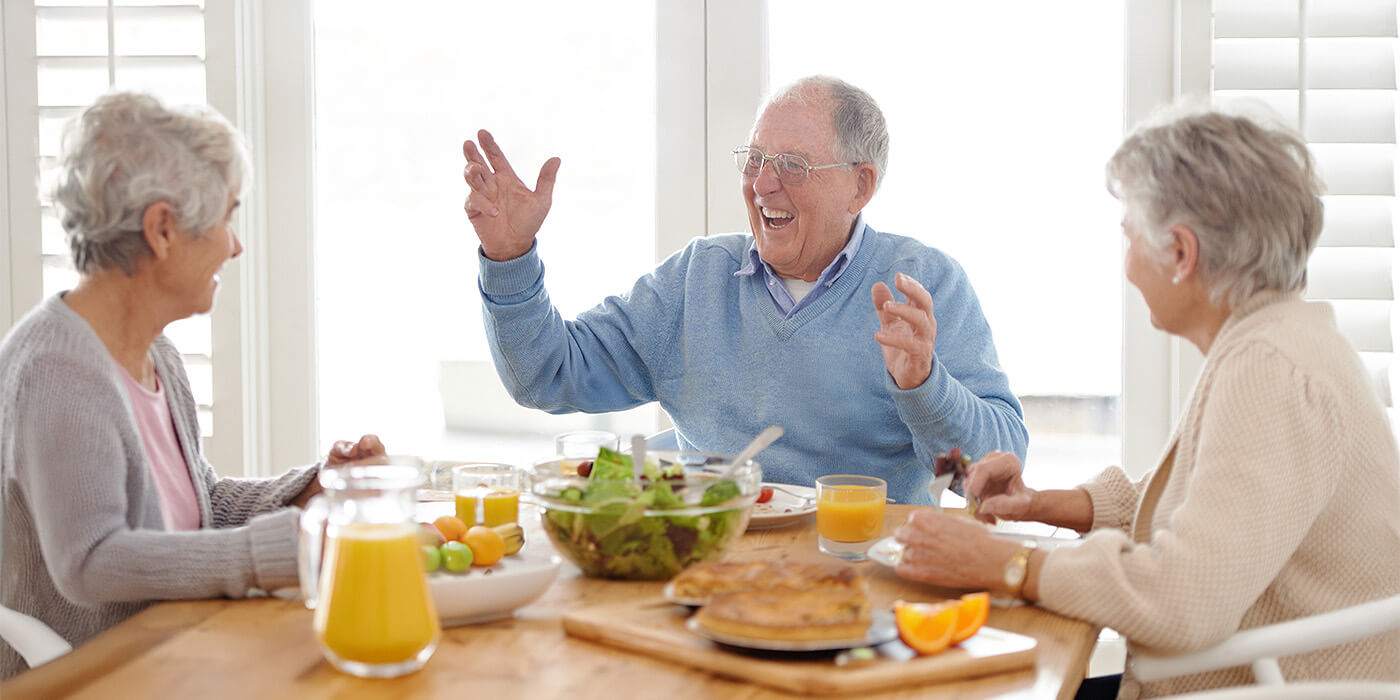 seniors-friends-enjoy-breakfast Seniors laugh at a conversation during breakfast