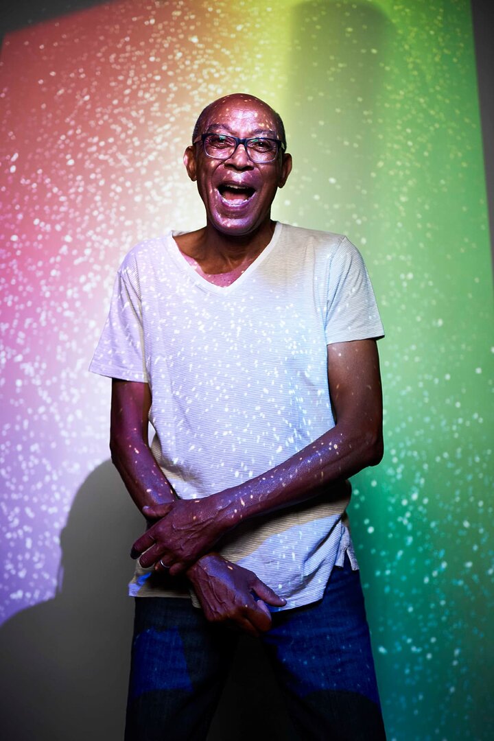 Senior man standing in the lights of tovertafel and laughing